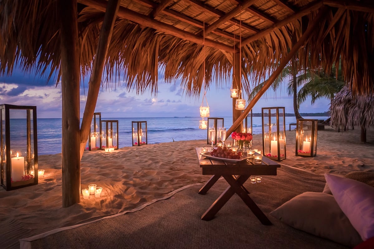Picnic area under a hut on the dand surrounded by candles and with a view of the sea at a resort in Samana, Dominican Republic.