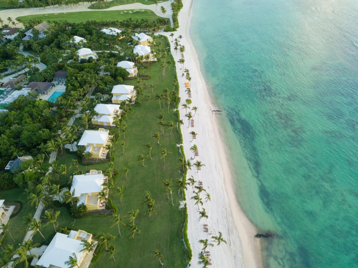 A bird's eye view of a beachfront resort in the Dominican Republic with palm trees and white sand.