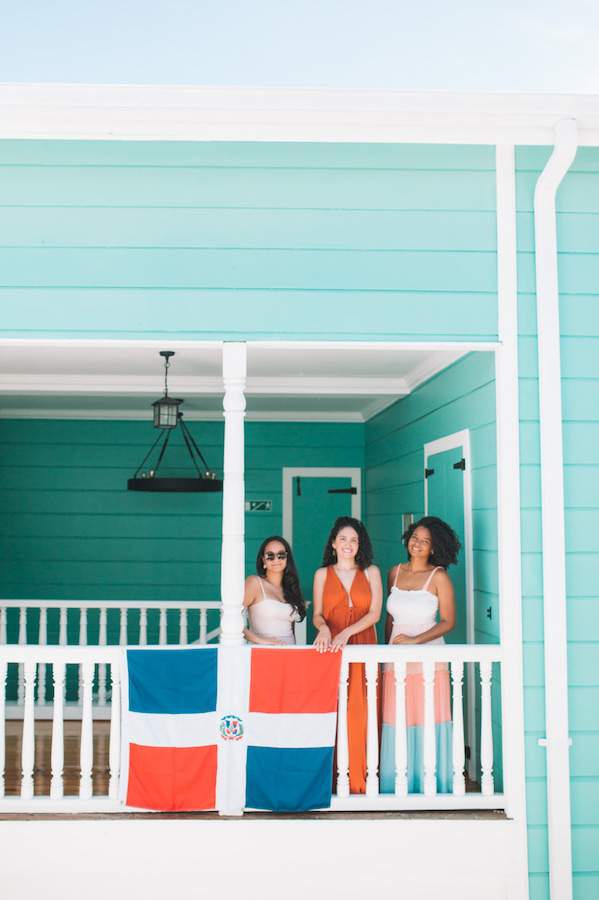 Four women posing behind the Dominican Republic flag at Museo Gregorio Luperon.