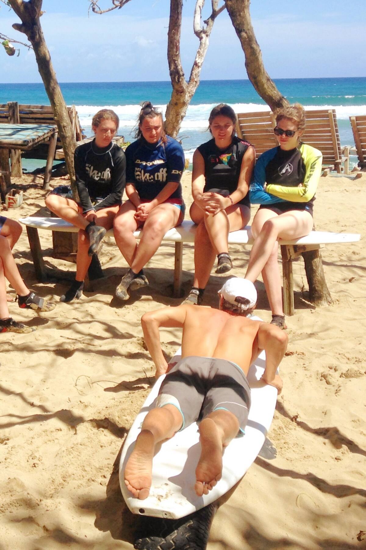 A surfing instructor teaching students at a beach in Puerto Plata.