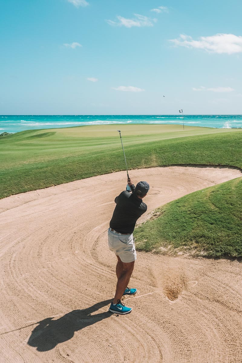 A man playing golf at a golf course near the sea in Punta Cana, Dominican Republic.