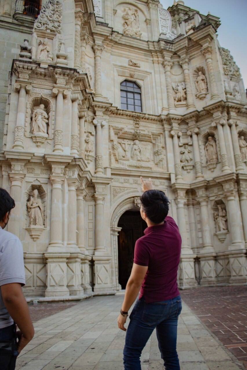 A tour guide discussing a church architecture to tourists on a tour in Oaxaca.