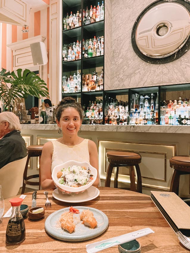 A woman dining in a Punta Cana Restaurant with a bar in the background.