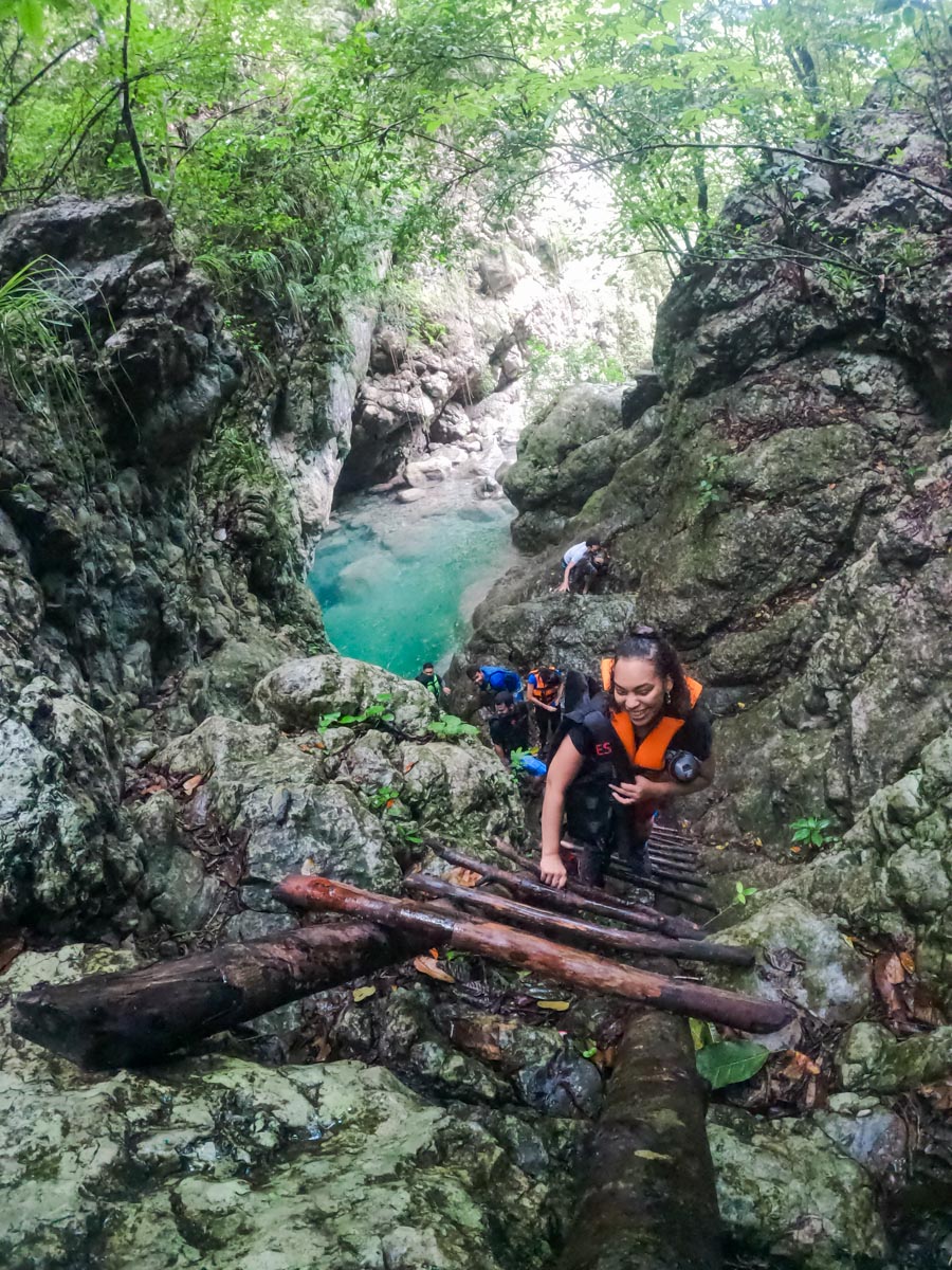 People climbing a ladder against rocks at El Tabernáculo.