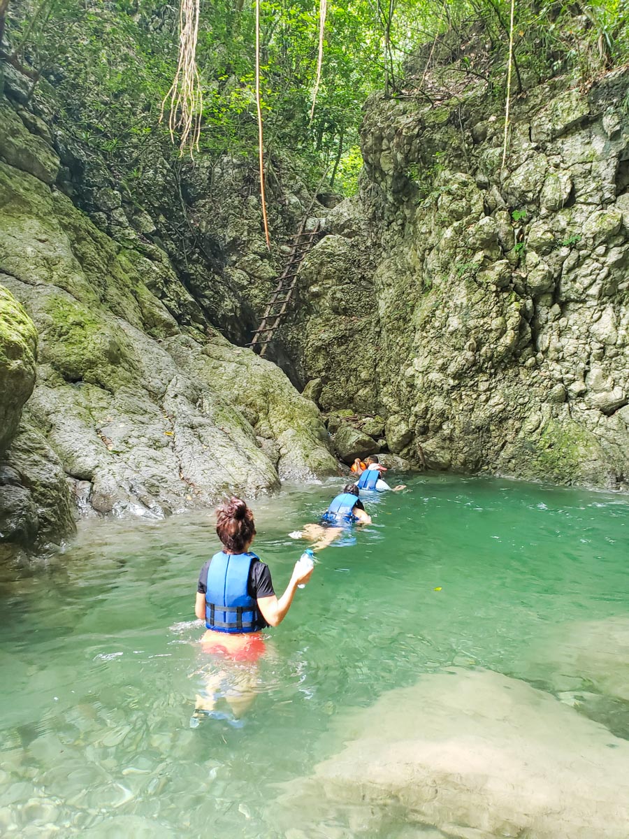 People hiking through the natural pool at El Tabernáculo.
