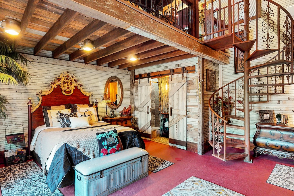 A bedroom in one of the boutique hotels in New Orleans which has a spiral staircase.