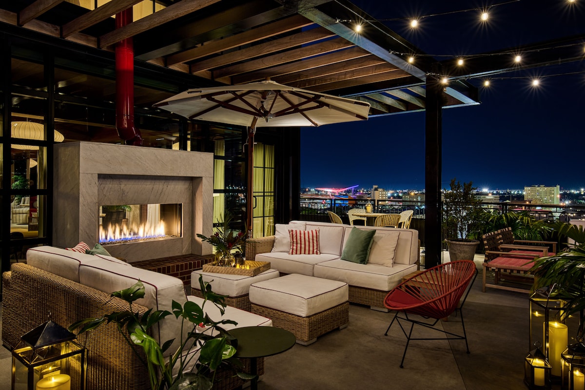 The outdoor rooftop chimney area of a hotel with chairs and plants.