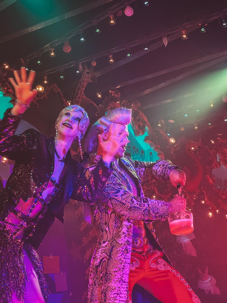 Two people performing at Company XIV, one of them pouring a drink