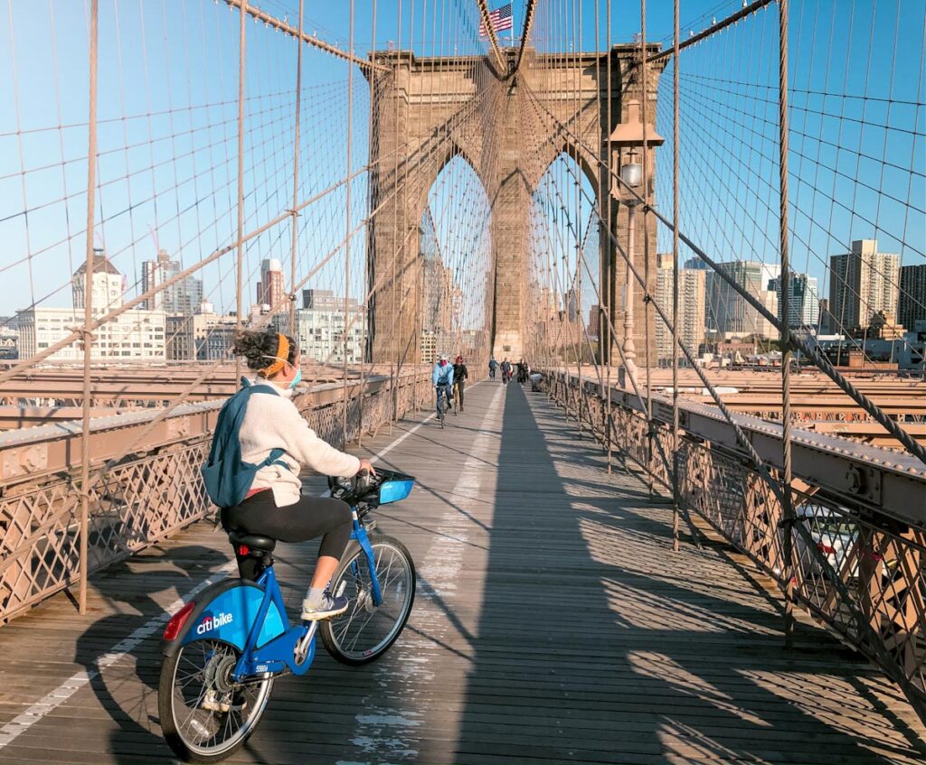 A woman biking at on Brooklyn Bridge