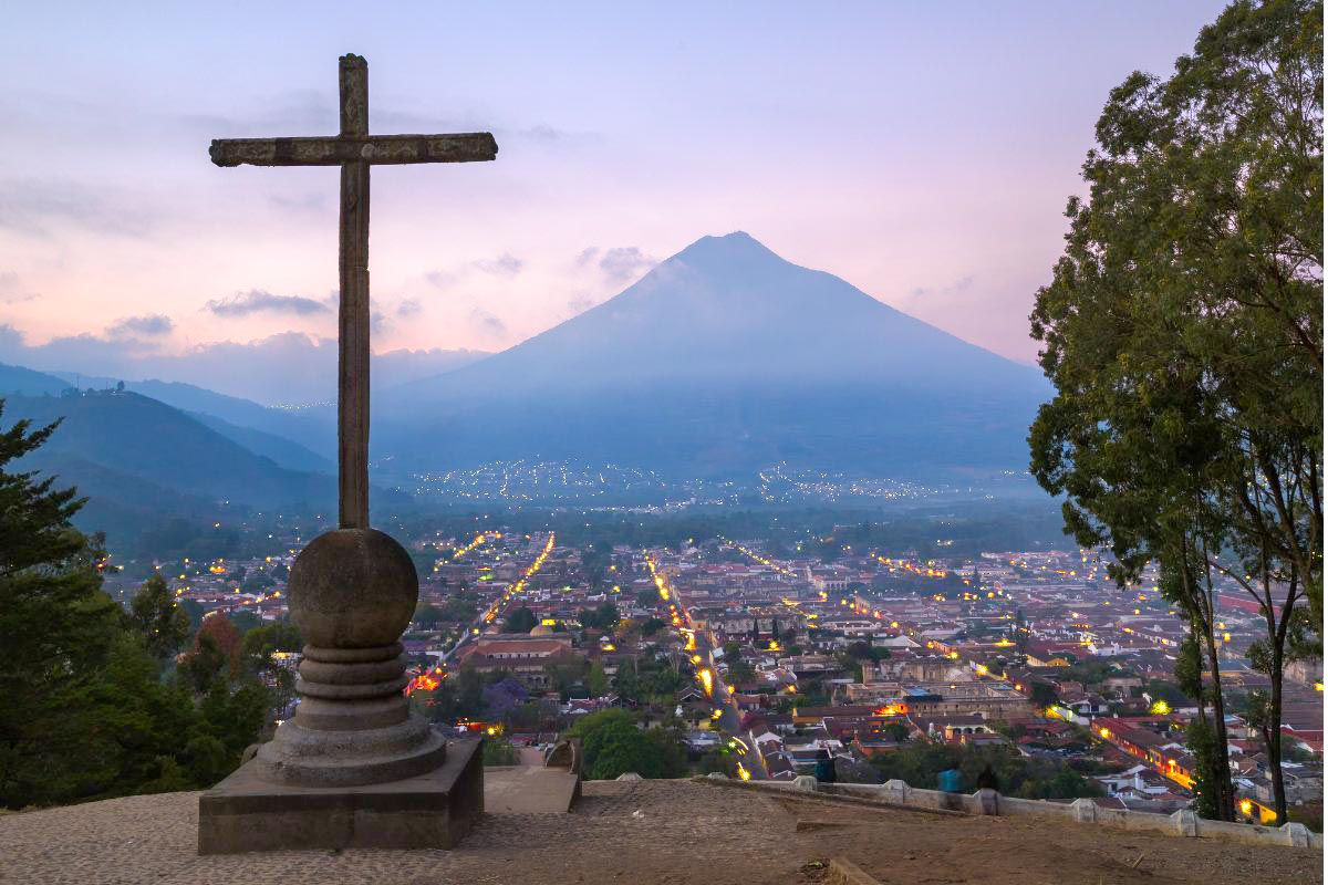 A cross at Cerro la Cruz with a volcano and the town in the background
