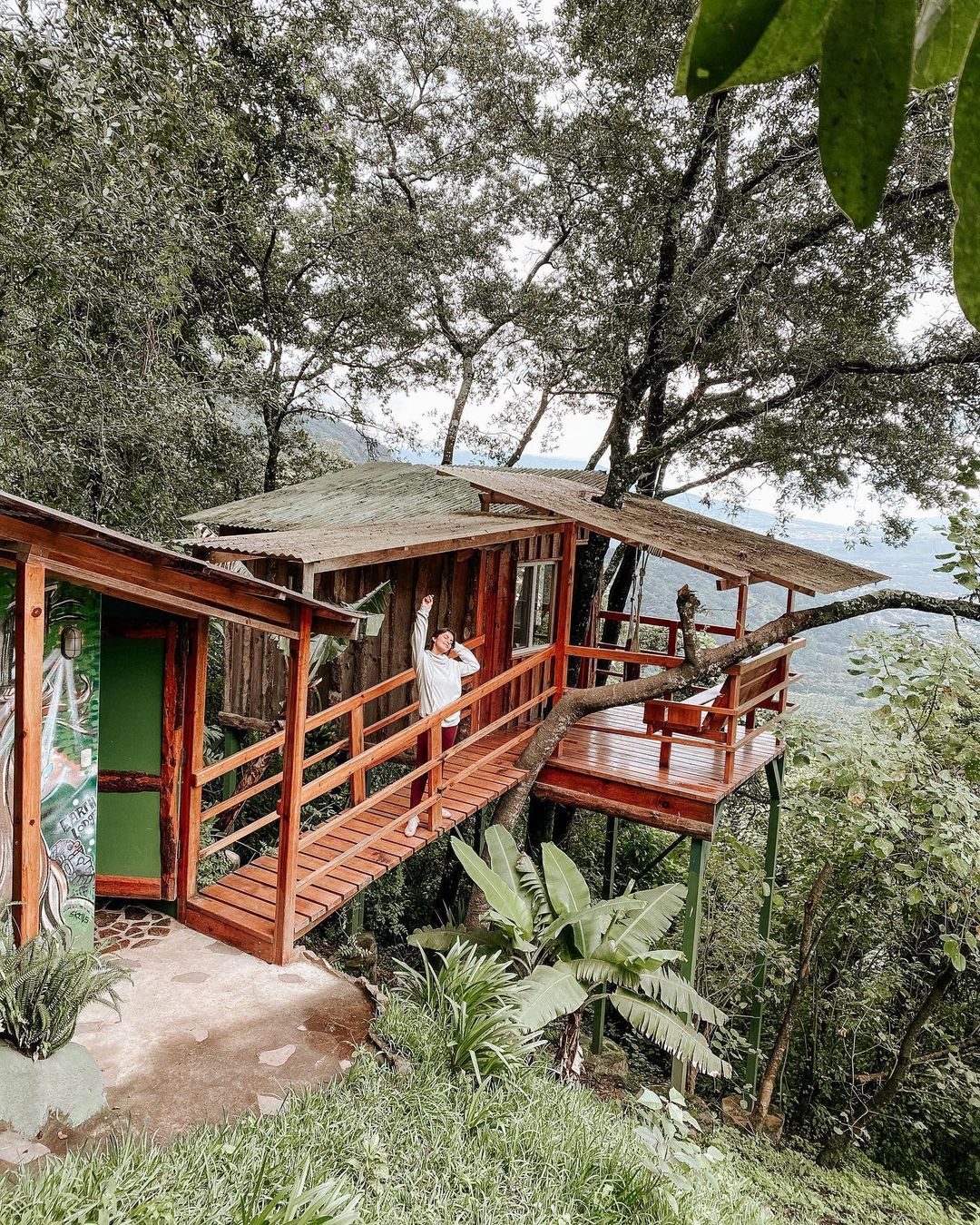 A woman on a bridge to a cabin at Earth Lodge