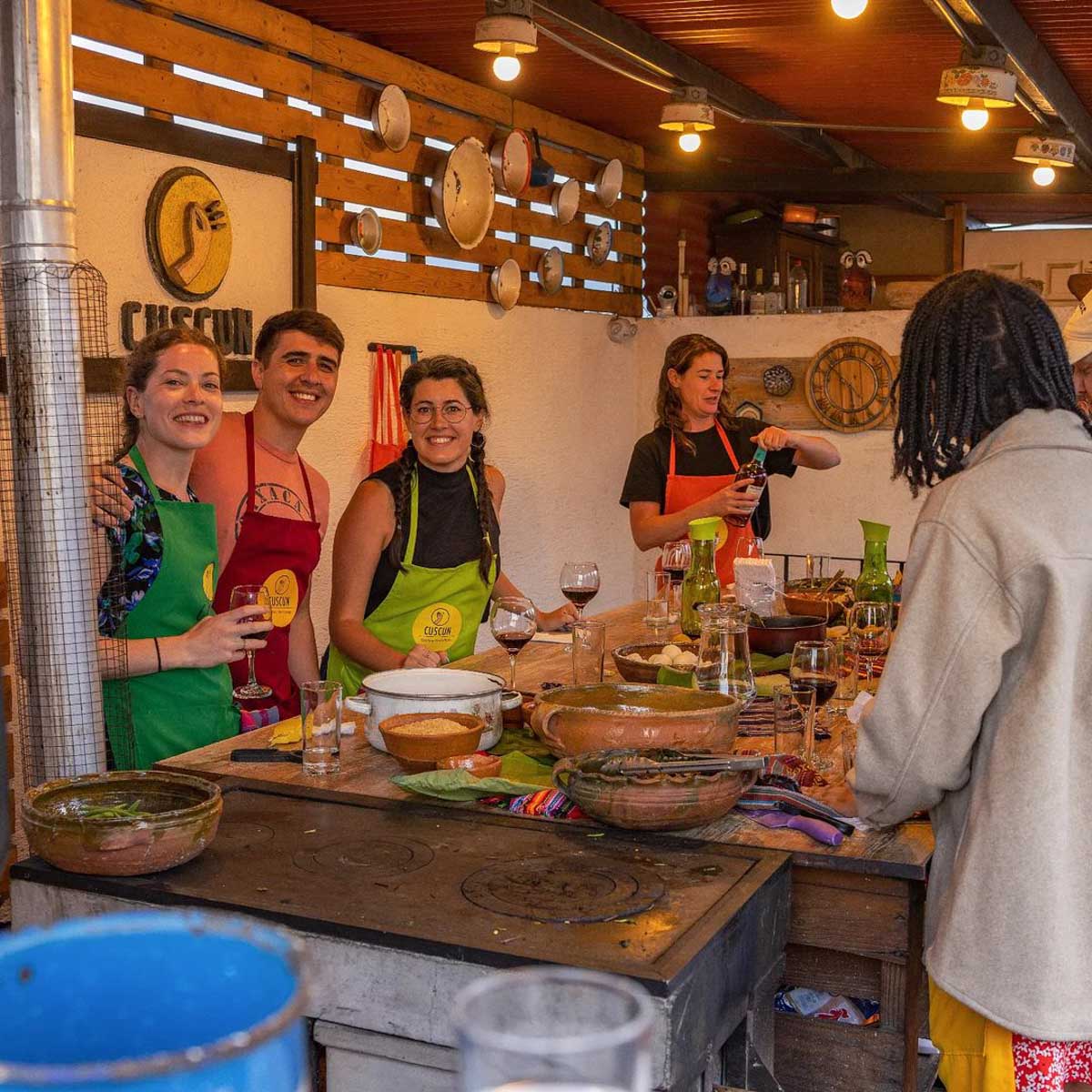 Five people drinking wine and preparing food at a Mayan food cooking class