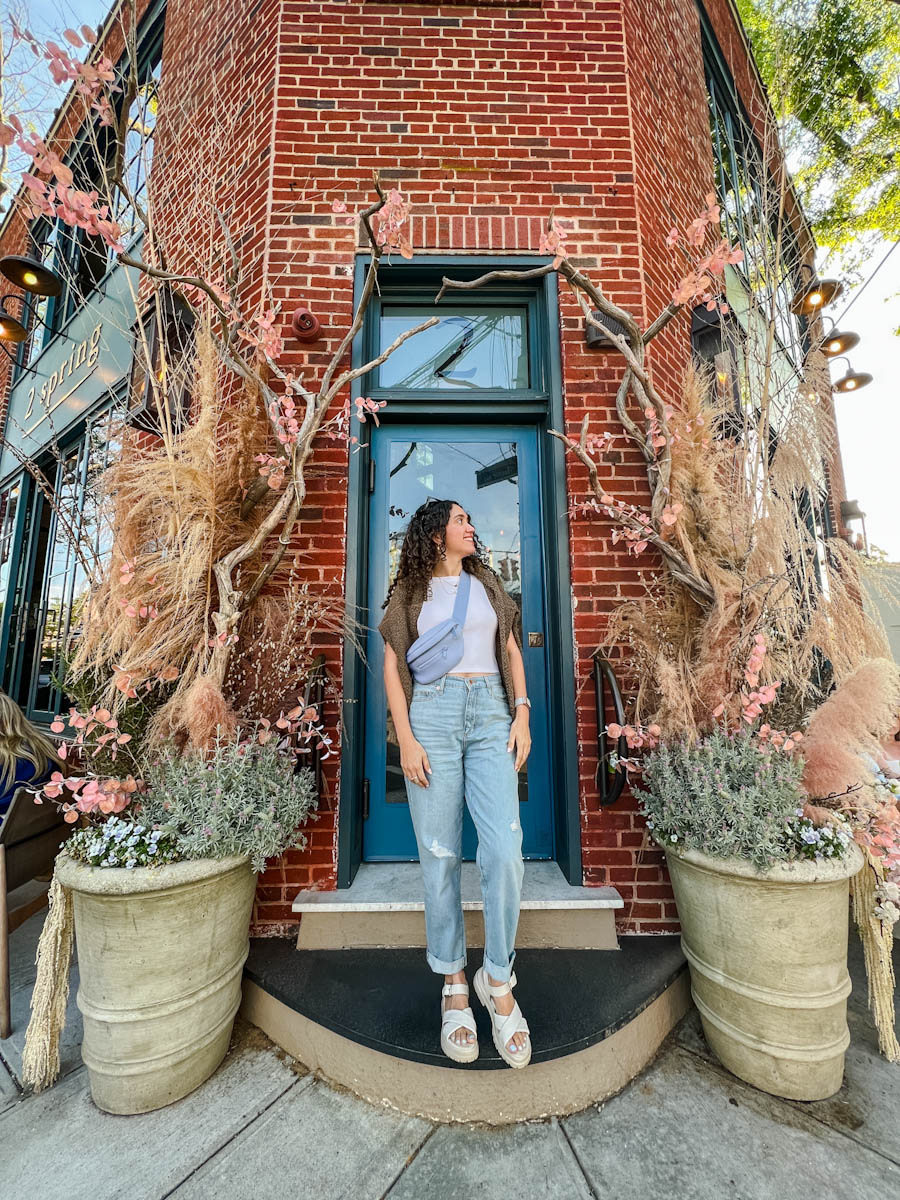 A woman posing outside a building with brick walls