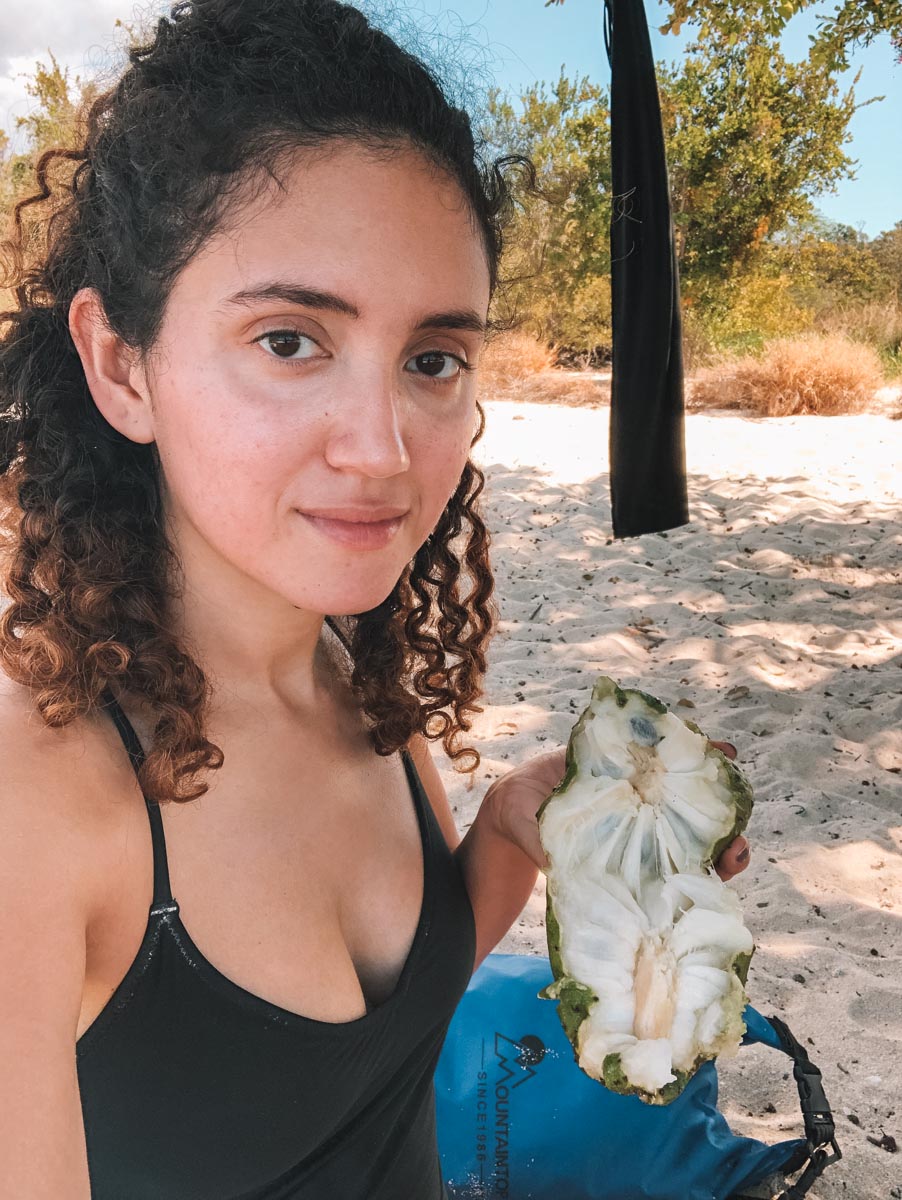 A woman holding an opened guanabana