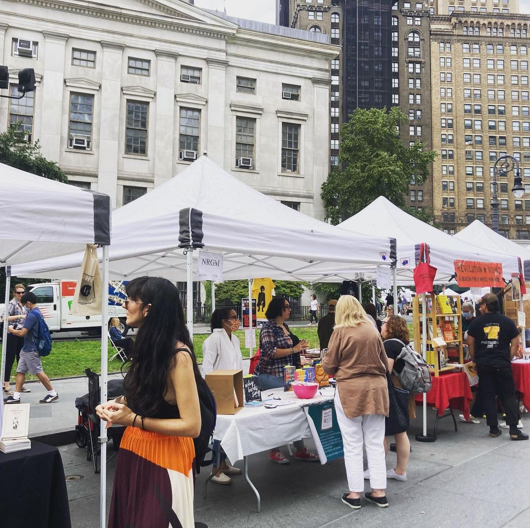 People interacting at booths at the Brooklyn Book Festival