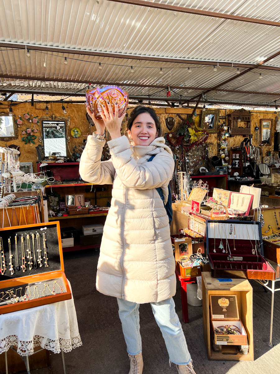 A woman in winter clothes holding an item at the Bushwick Market