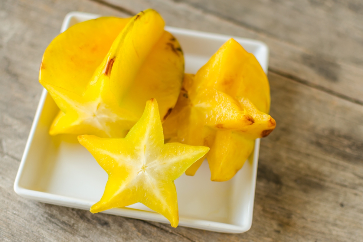 Sliced carambola or star fruit on a white square plate