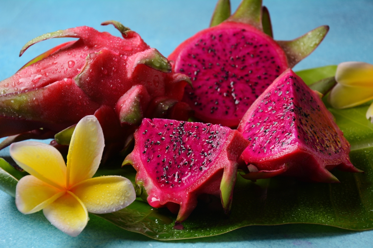 Whole and sliced pitahaya or dragon fruit on a leaf