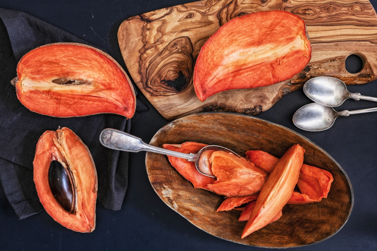Zapote, , a dominican fruit, opened and sliced, either on a bowl, wooden chopping board, and cloth