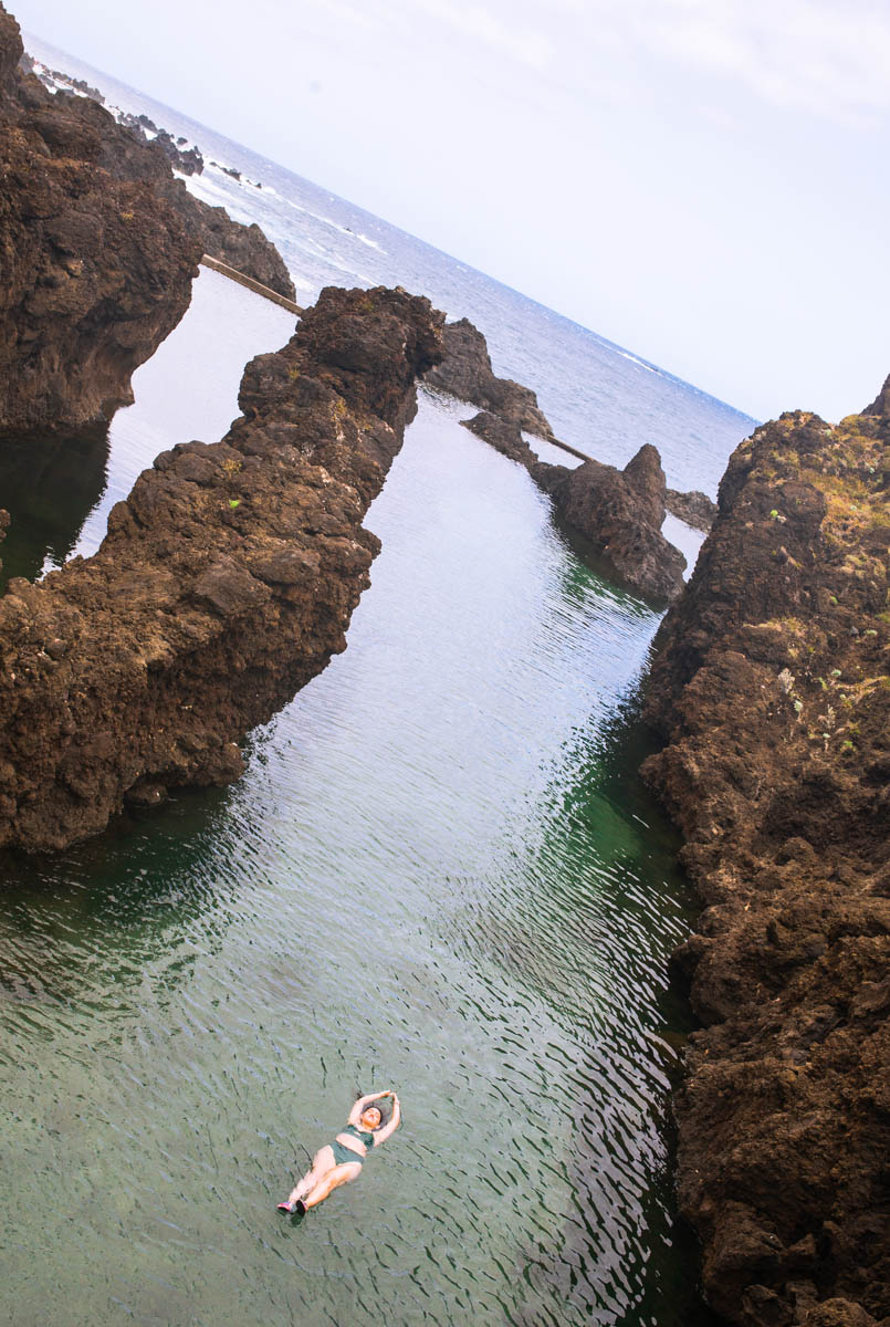 A woman floating on Porto Moniz natural pool in Madeira