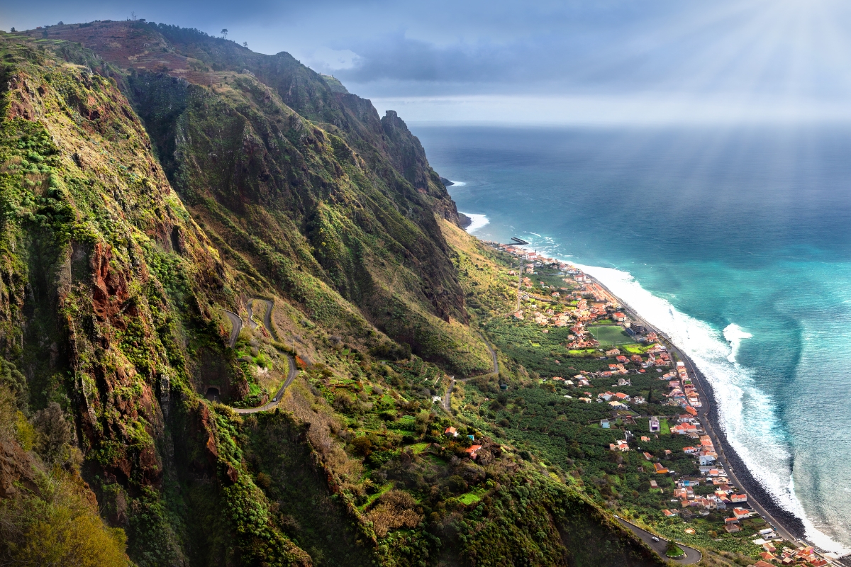 The aerial view of the coastal West Madeira with the mountains on the left and sea on the right