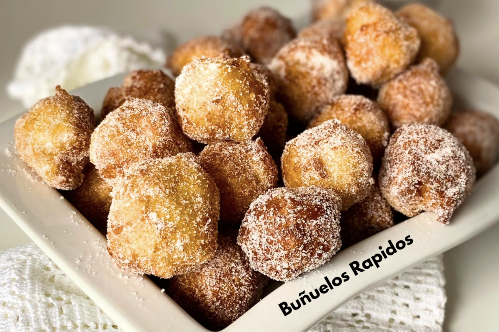 Deep-fried round breads sprinkled with sugar.