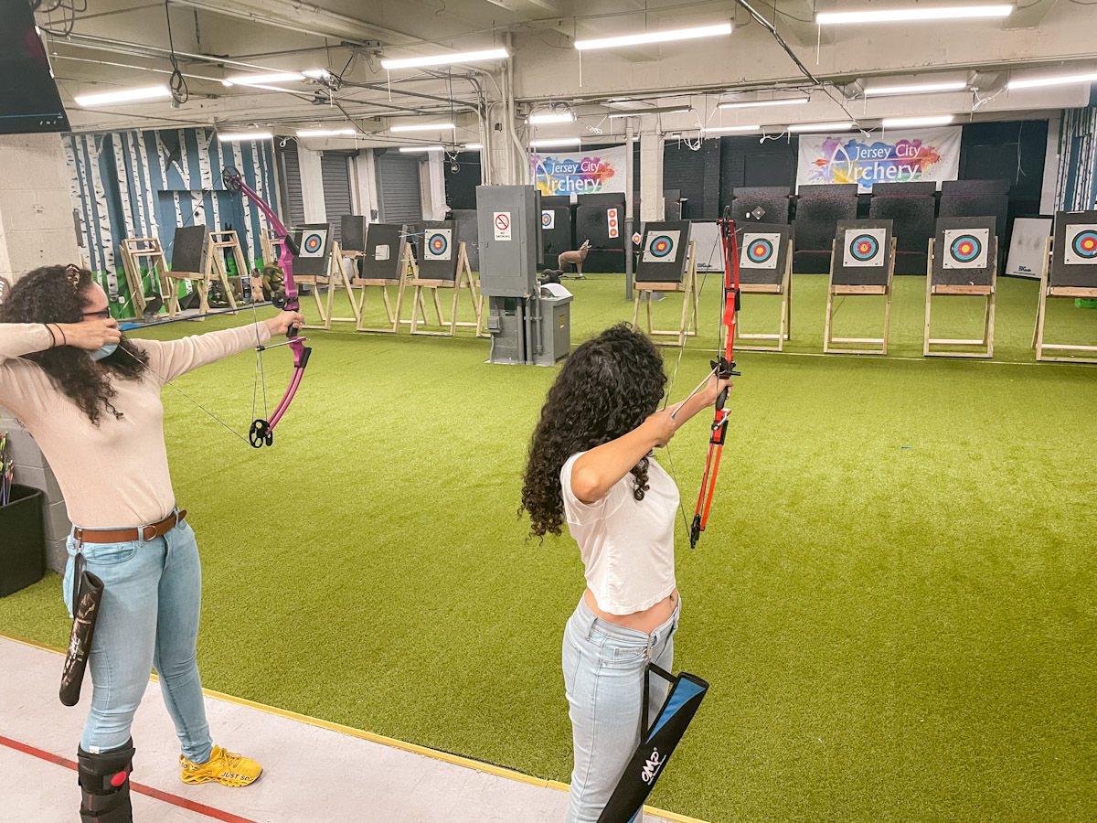 Two women on an archery lesson in NYC indoor