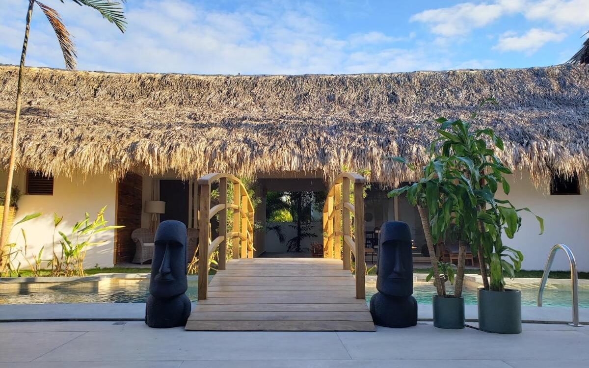 A small bridge at an outdoor swimming pool area of a boutique hotel with tropical vibes.