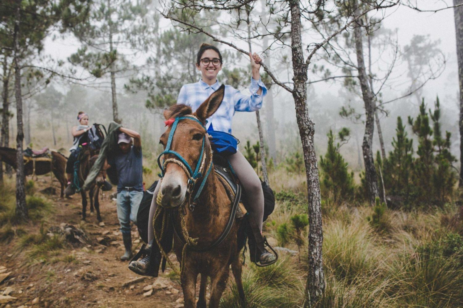 A woman riding a horse on Pico Duarte.