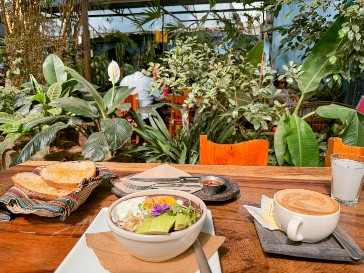 Food and drinks on a table at a garden restaurant in Antigua, Guatemala.