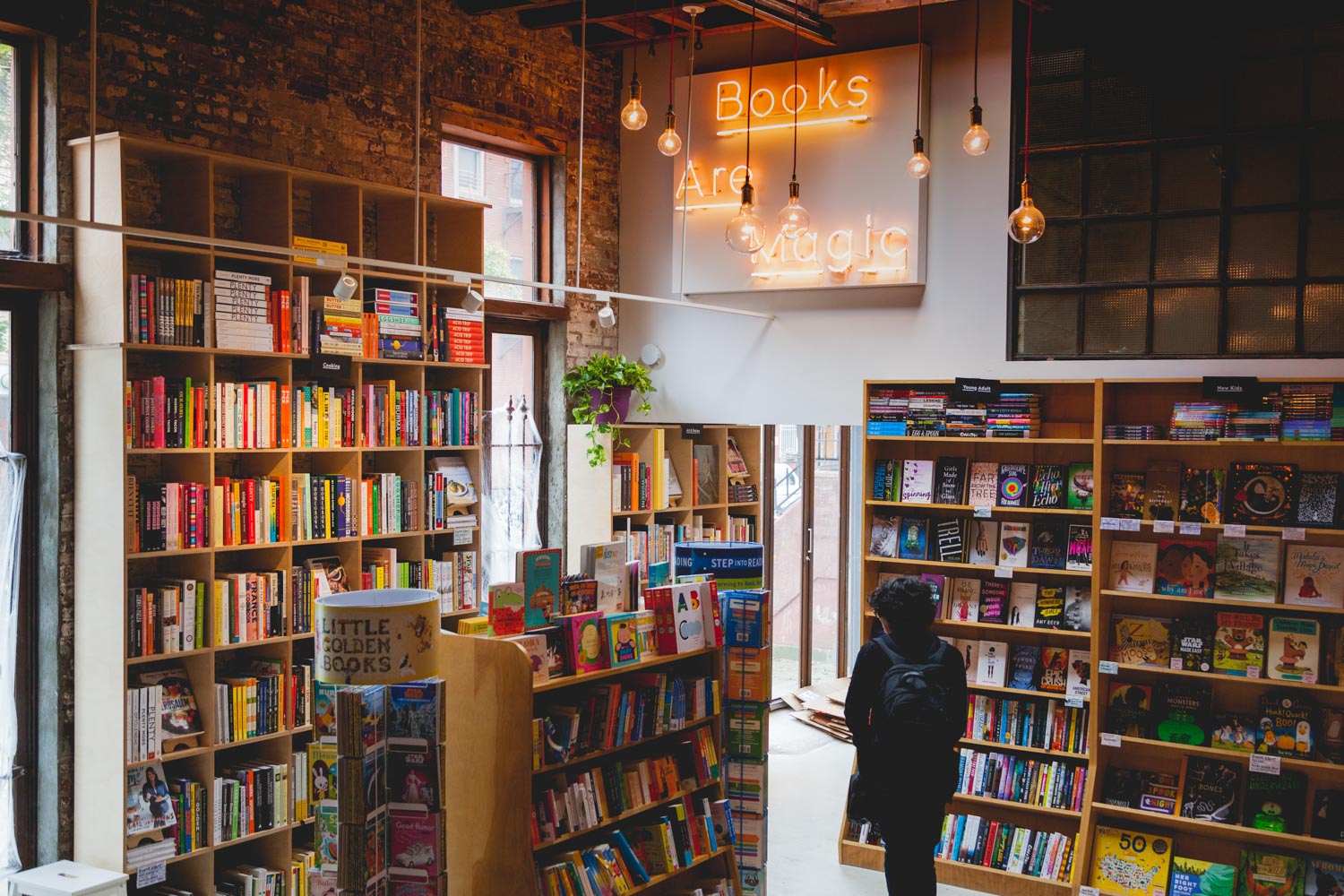 A man inside Books are Magic, one of the independent NYC bookstores, surrounded by shelves of books.