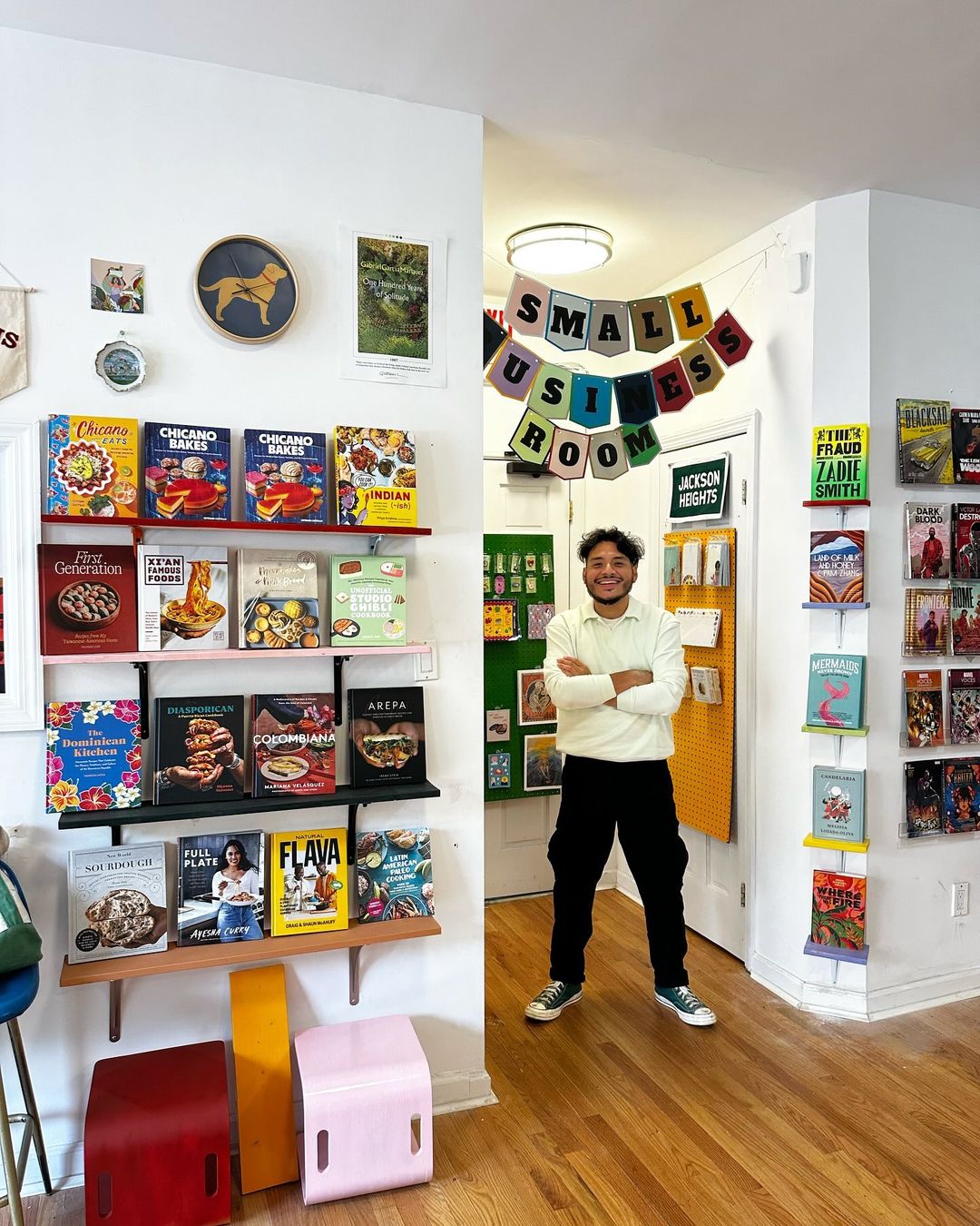 A man standing with his arms crossed in a bookstore in New York City.