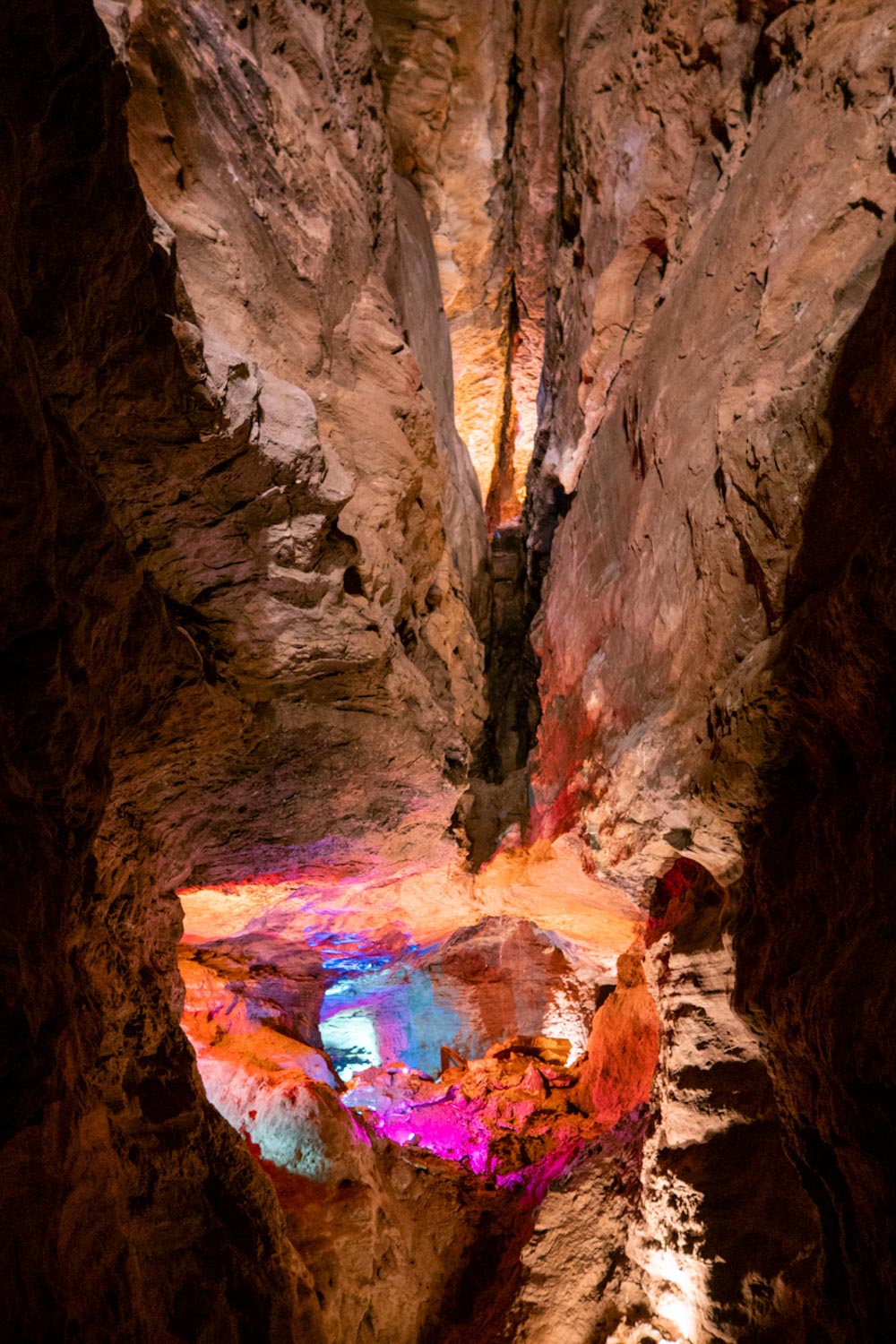 A waterfall lit with colorful lights inside Laurel Caverns in Pennsylvania.