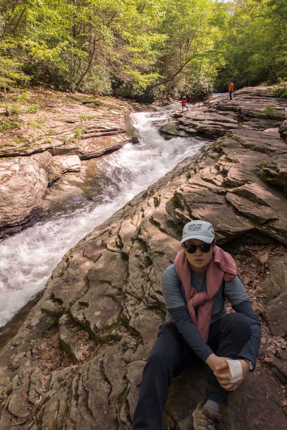 A woman standing on the rocks above a river water slide in Laurel Highlands Pennsylvania.