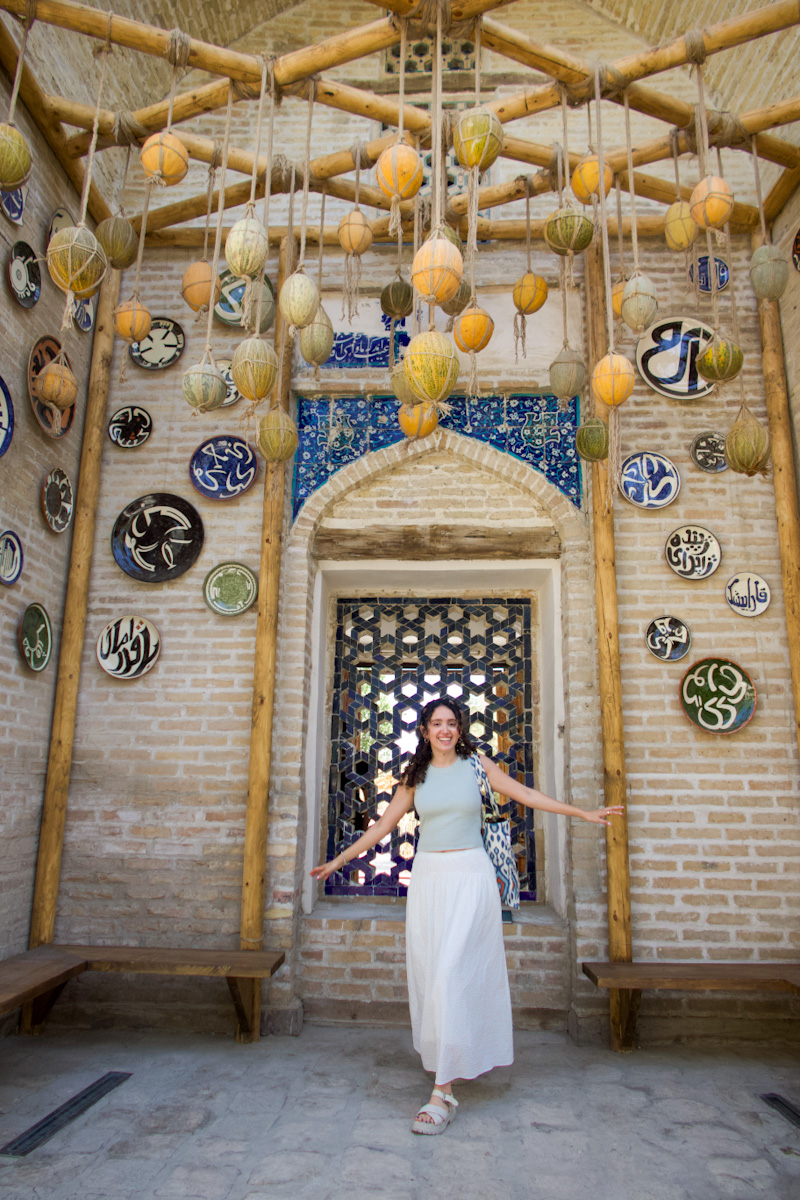 A woman standing in front of an art exhibit in Bukhara, Uzbekistan.