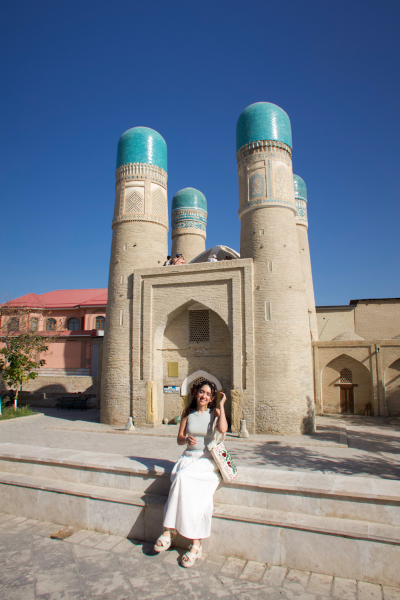 A woman standing in front of a historic building in Uzbekistan.