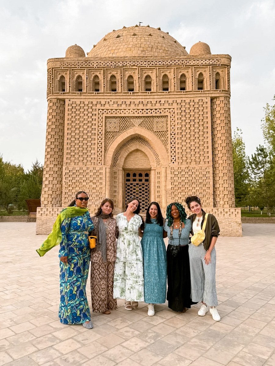 Four women standing in front of a historic mausoleum in Uzbekistan.