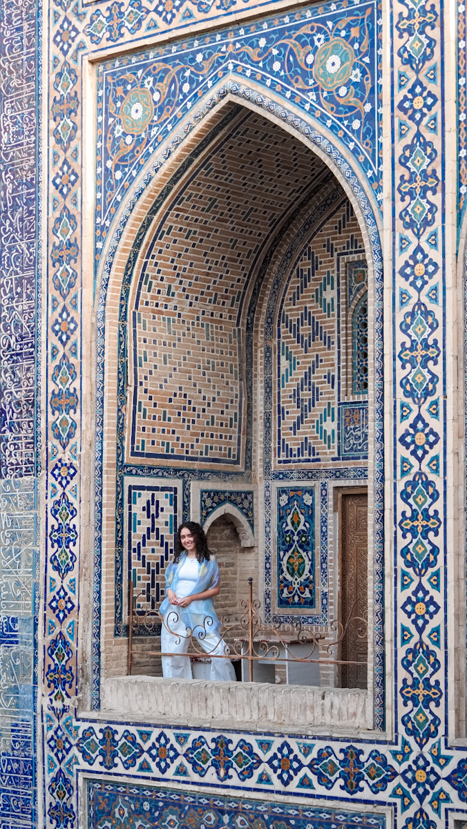 A woman standing at a balcony at a cafe in Registan Square in Samarkand.