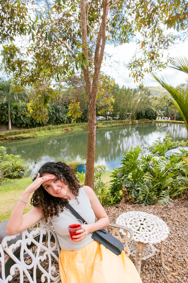 A woman sitting on a chair at a farm with a pond in Puerto Rico.