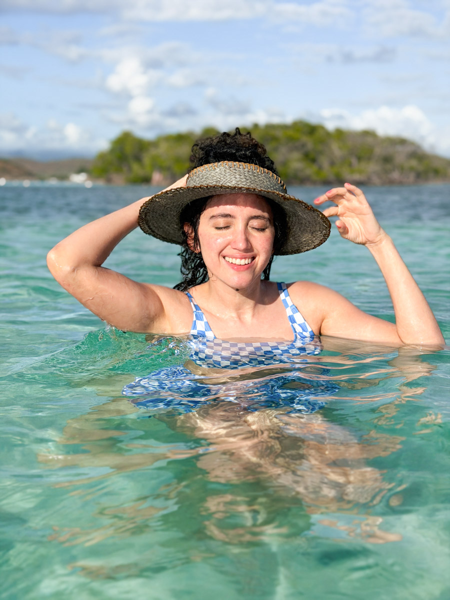 A woman wearing a hat swimming in the sea in Puerto Rico.