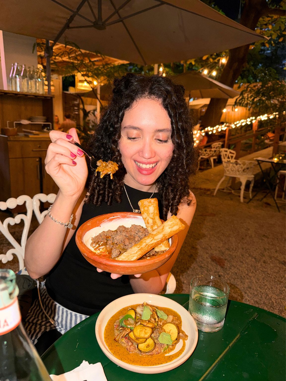 A woman holding a bowl of food inside a restaurant in Puerto Rico.