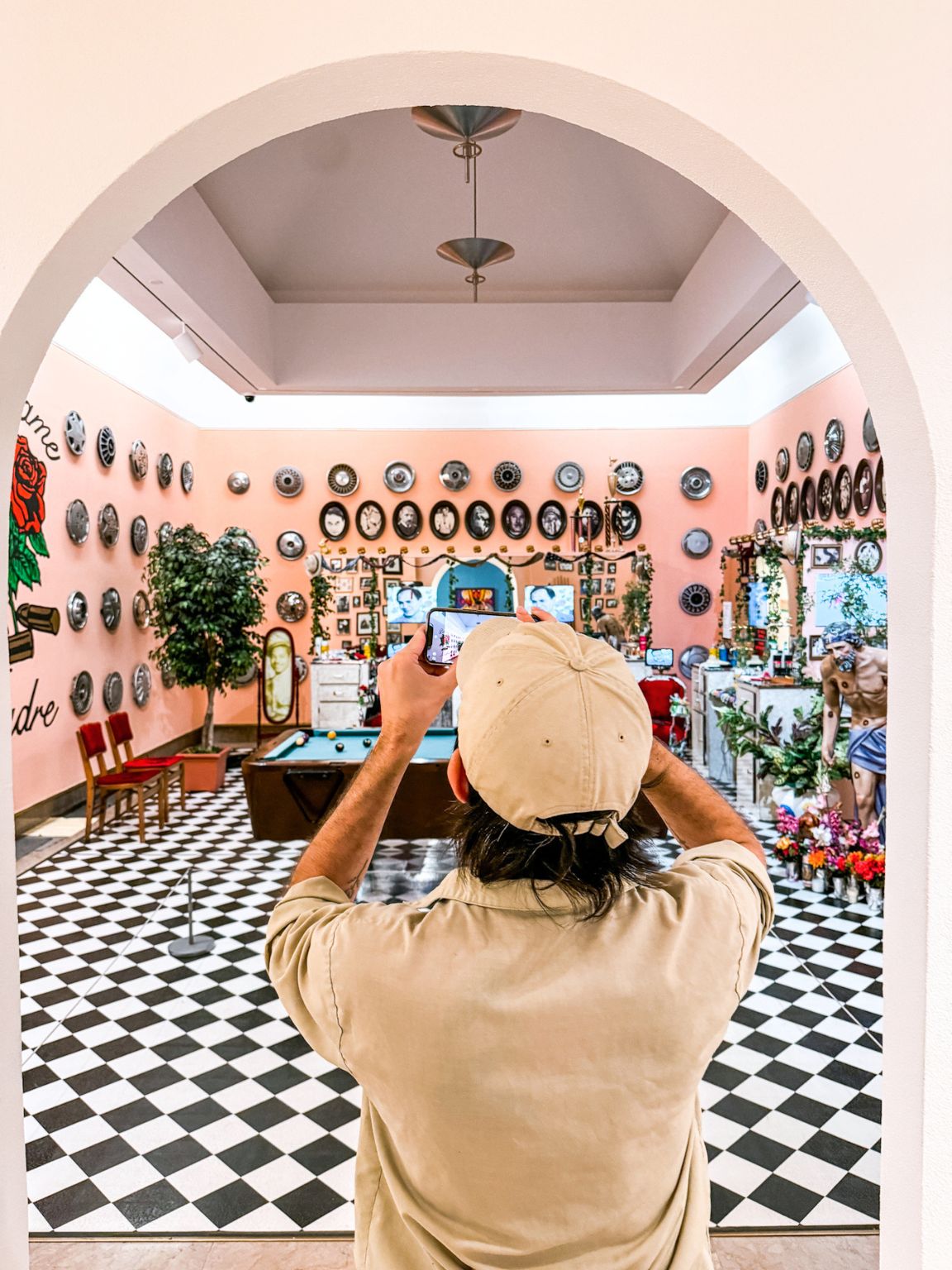 A person in polo and cap taking a picture of a museum's interior in Puerto Rico.