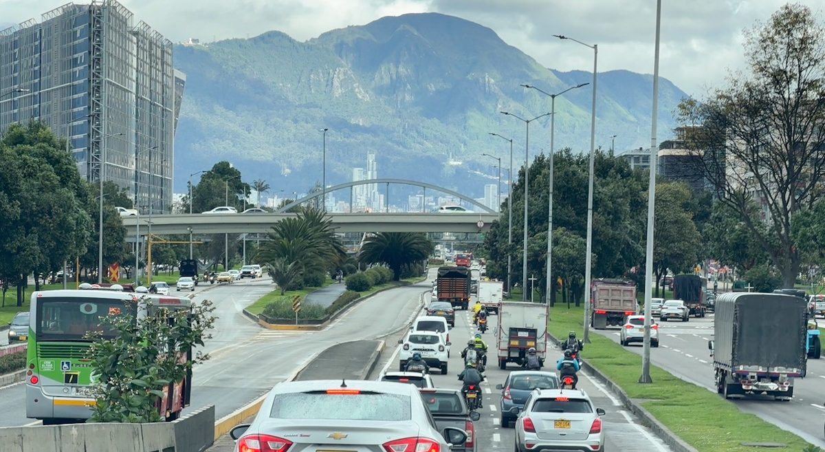 Cars on a road in Bogota with a view of mountains.