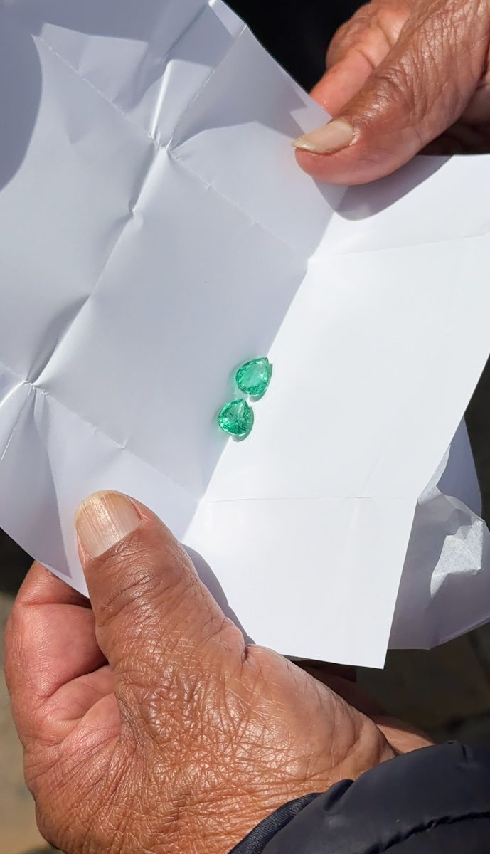 Two pieces of emerald gems on paper.