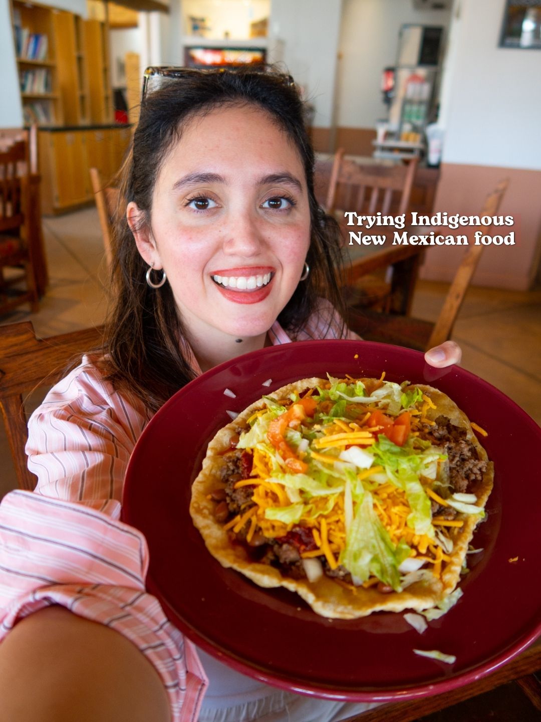 A woman holding a plate of tacos.