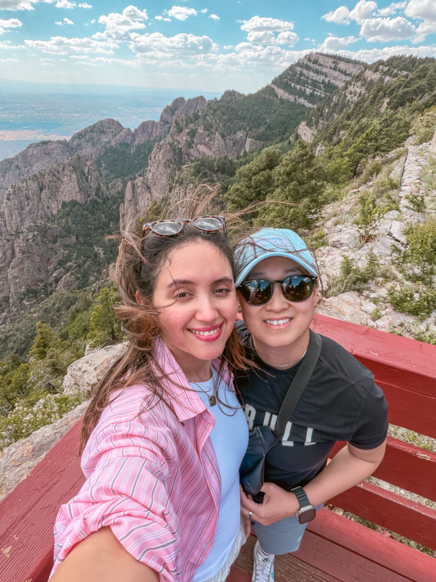 Two women at a view point with the Sandia Mountains view in the background in Albuquerque, New Mexico.