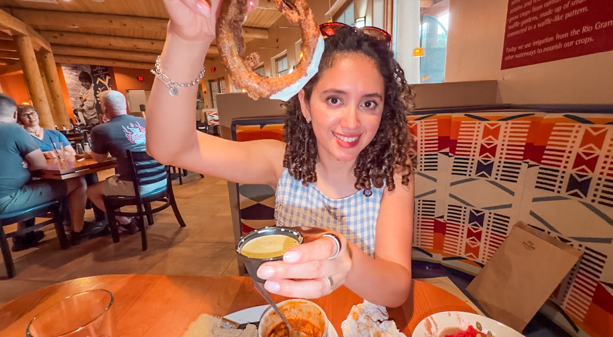 A woman holding food inside a restaurant in Albuquerque, New Mexico.