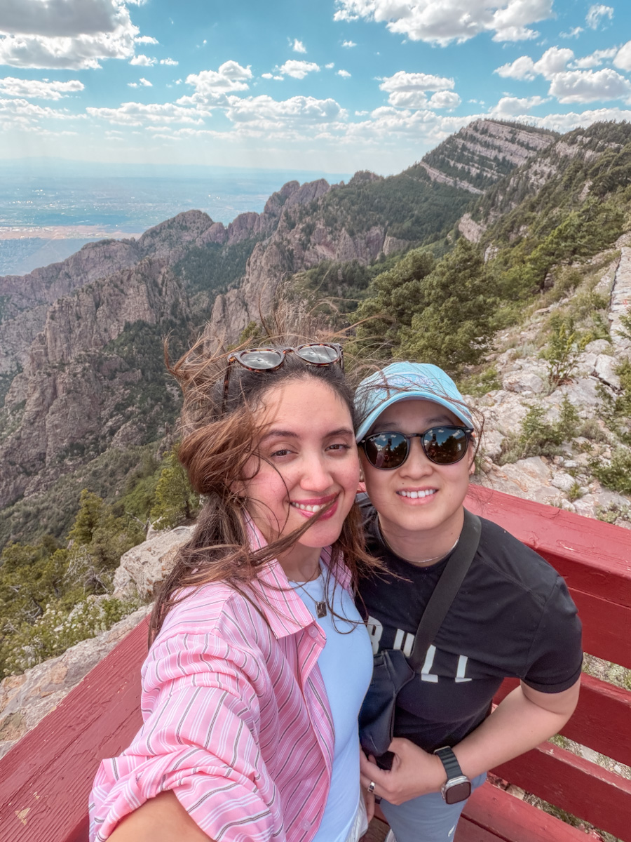 Two women at a view point with the Sandia Mountains view in the background in Albuquerque, New Mexico.