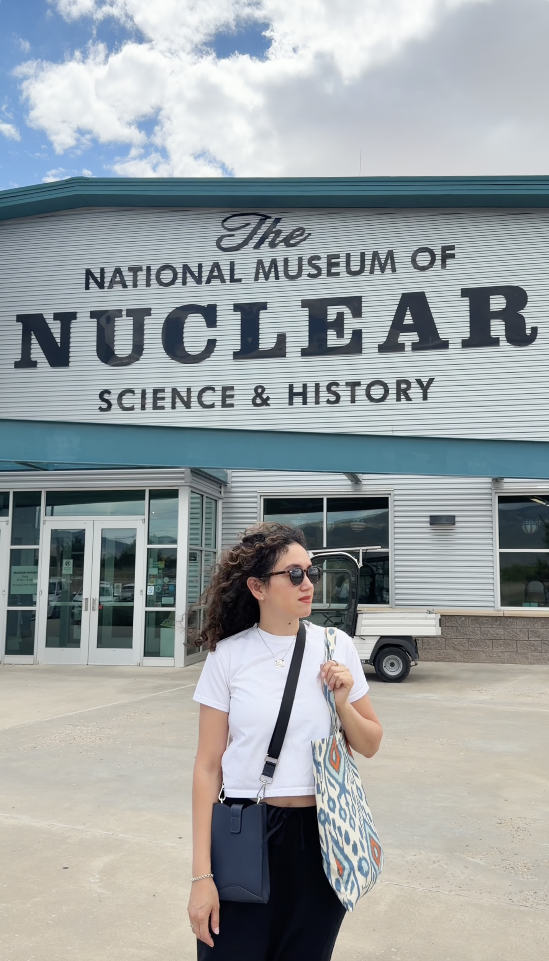 A woman standing in front of the building of The National Museum of Nuclear Science & History in Albuquerque, New Mexico.